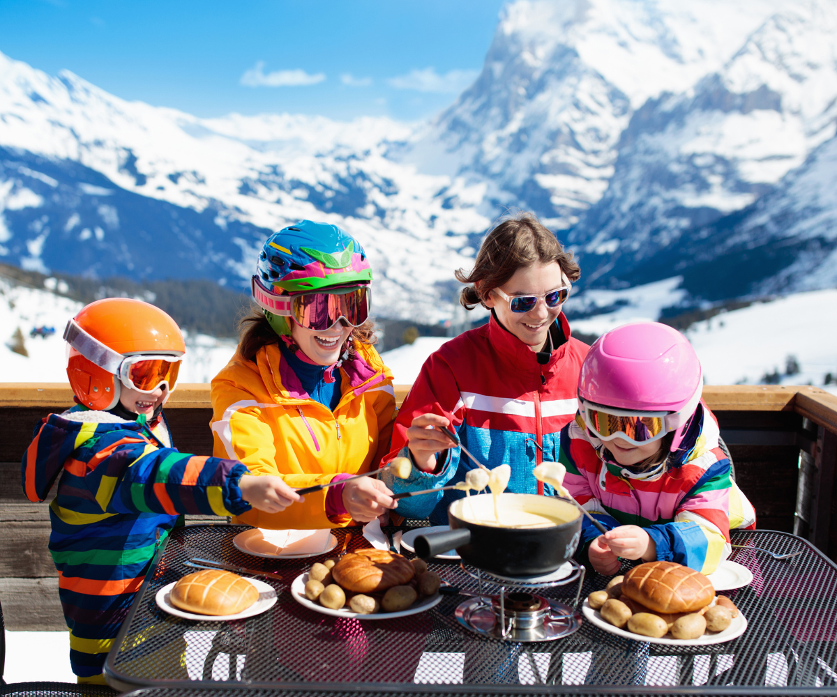 family of 4 in the Swiss mountains enjoying fondue living life in Switzerland